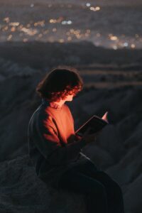man with book in outdoors at night