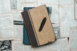 vintage books and feather on old pages